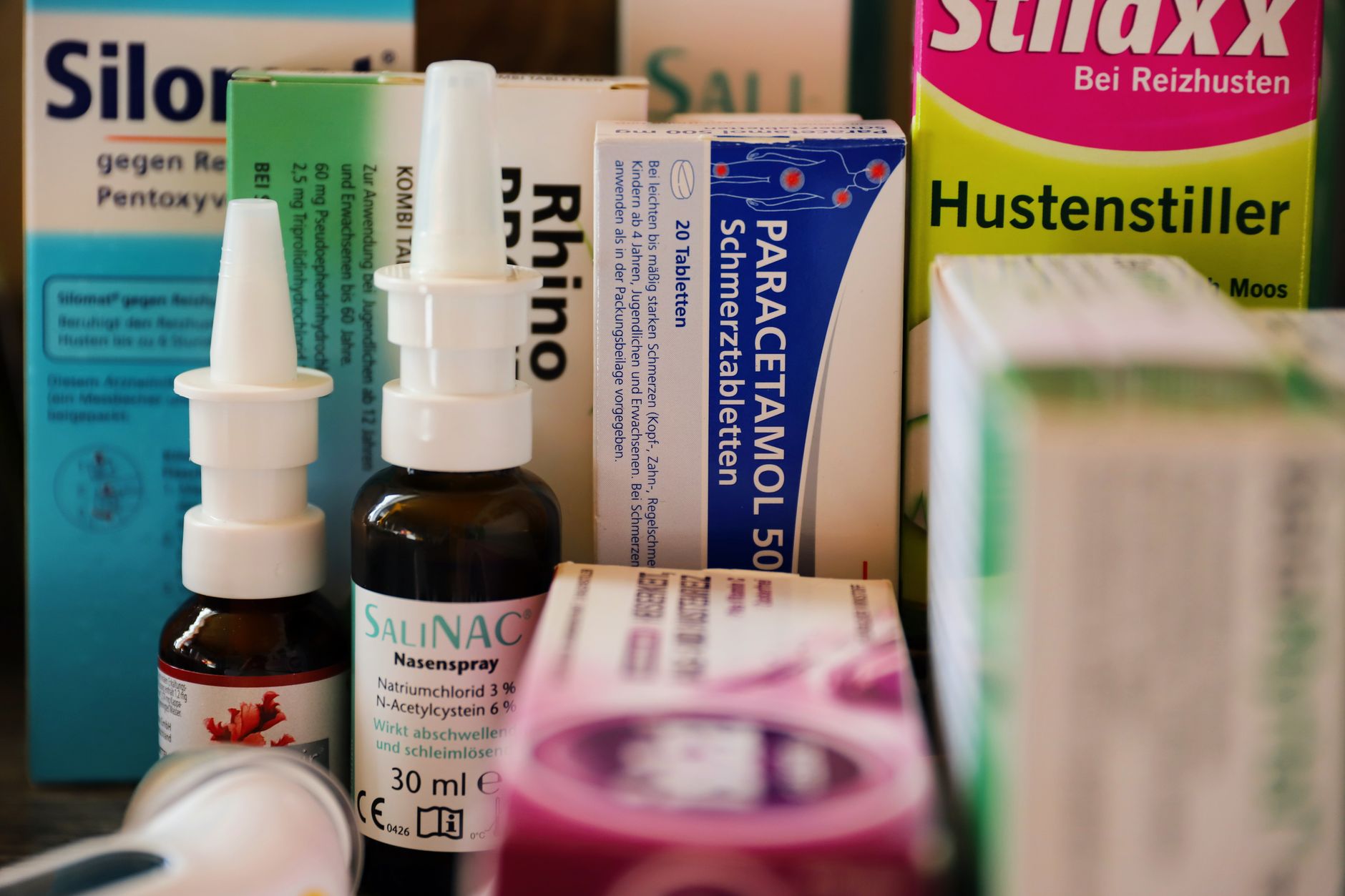 Woman using a nasal spray at the bathroom mirror ahead of grass pollen season