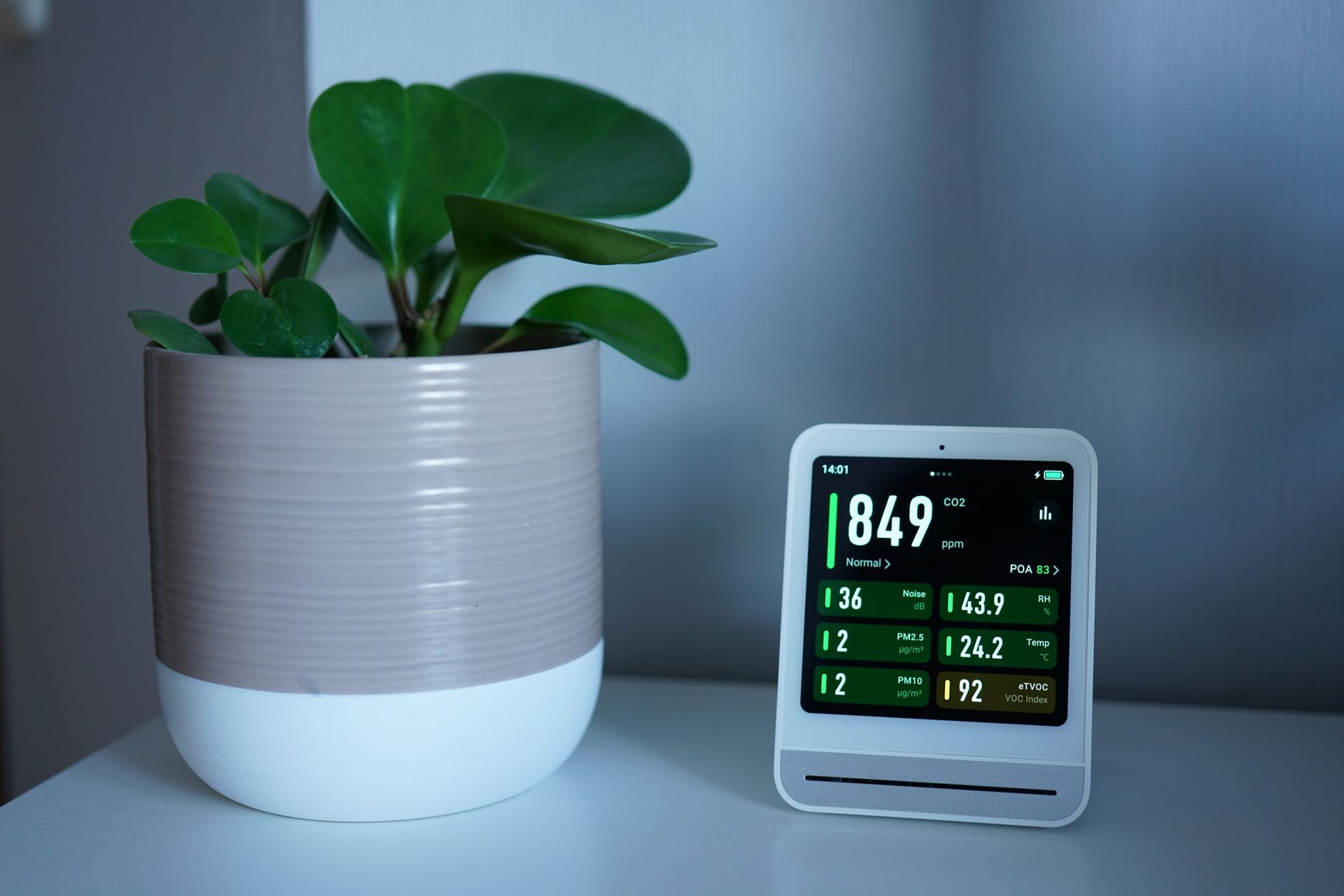 HEPA air purifier running beside a bed in a bedroom with the windows closed