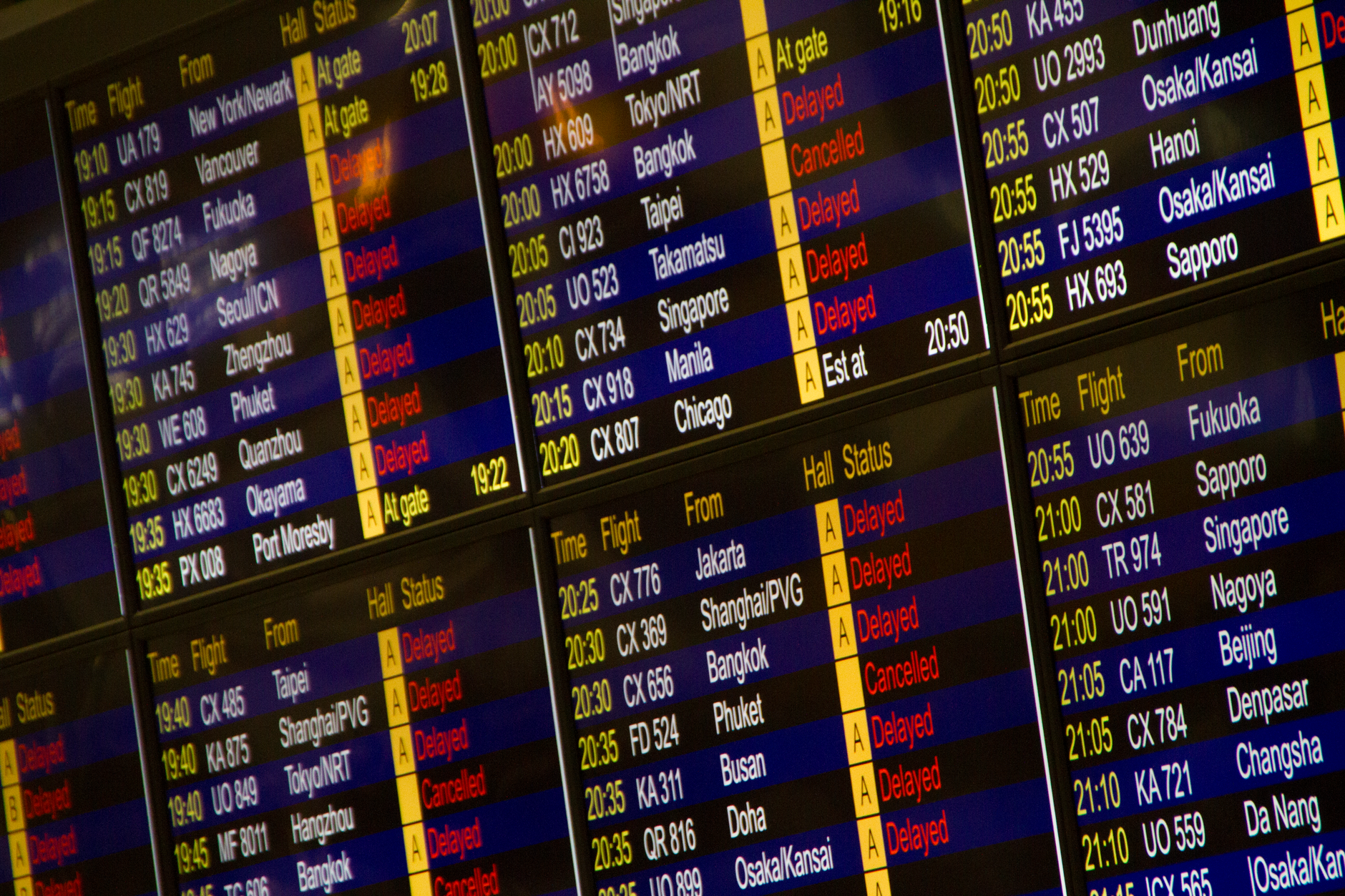 Close-up of digital flight information board showing arrivals and departures at an airport, illustrating Which day you fly matters ten times more than when you book