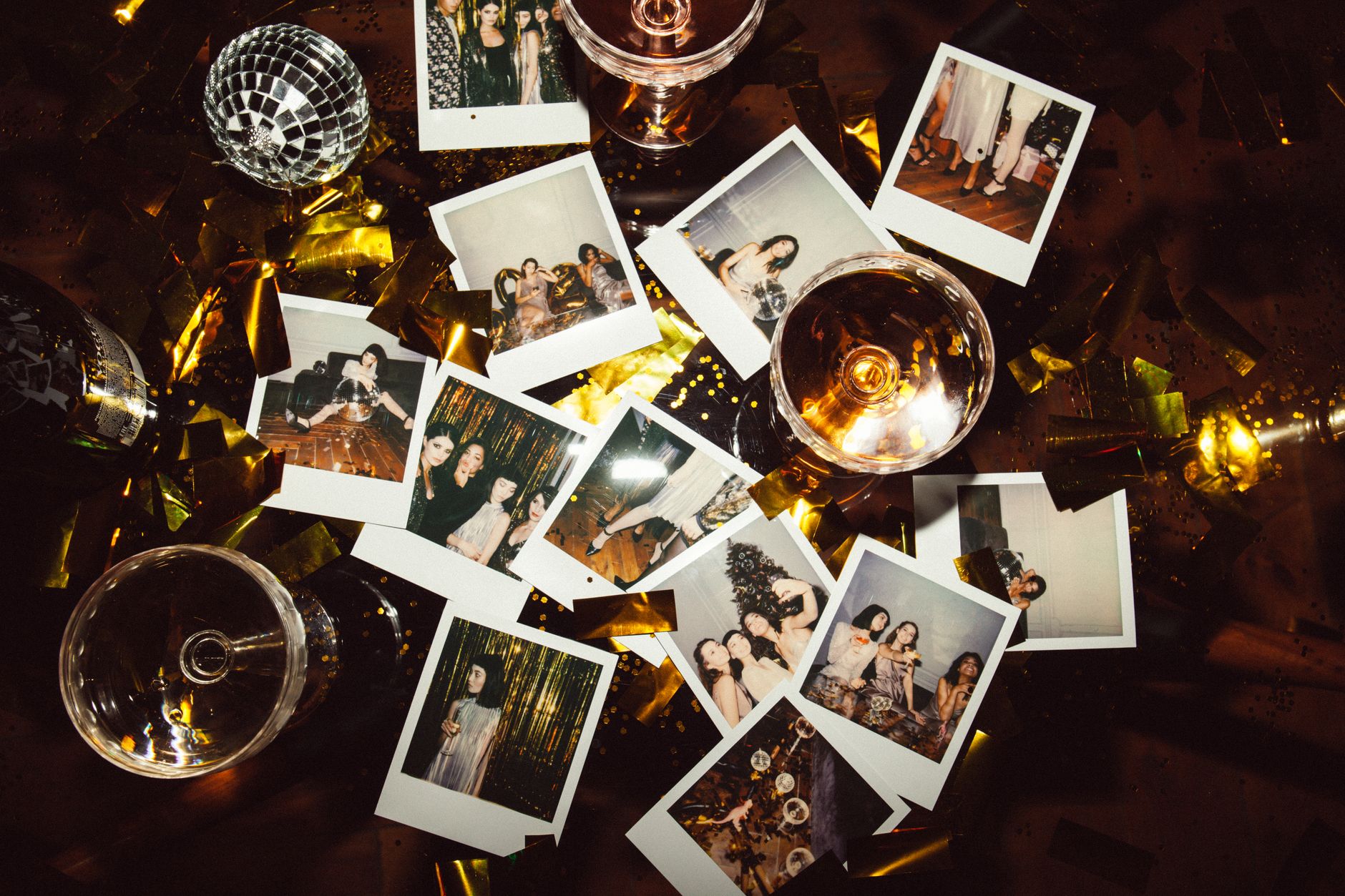 A collection of polaroid photos and glasses on a festive table, capturing party memories, illustrating The look comes from small sensors and direct flash