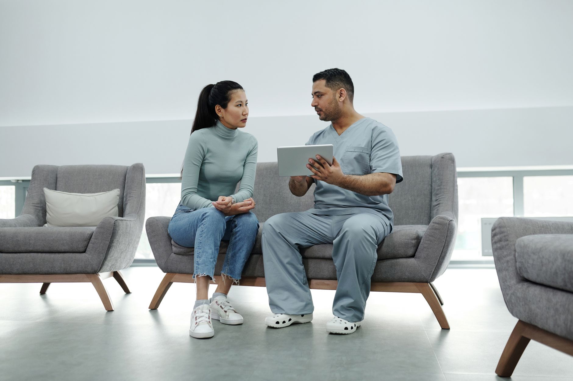 Healthcare provider consulting a patient with a tablet, emphasizing technology in healthcare, illustrating Most heart attack symptoms in women still include chest pain