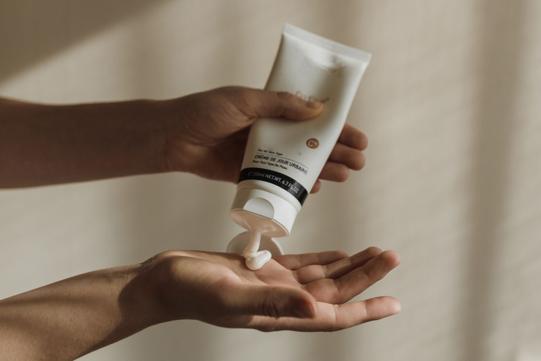 Sunscreen lotion squeezed into a palm to measure a full one-ounce application