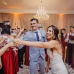 Wedding guests raising glasses at a summer reception