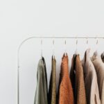 A minimalist clothing rack displaying neutral-toned outfits in an organized indoor setting, illustrating How to Build a Capsule Wardrobe: 30 Essential Pieces for Year-Round Style