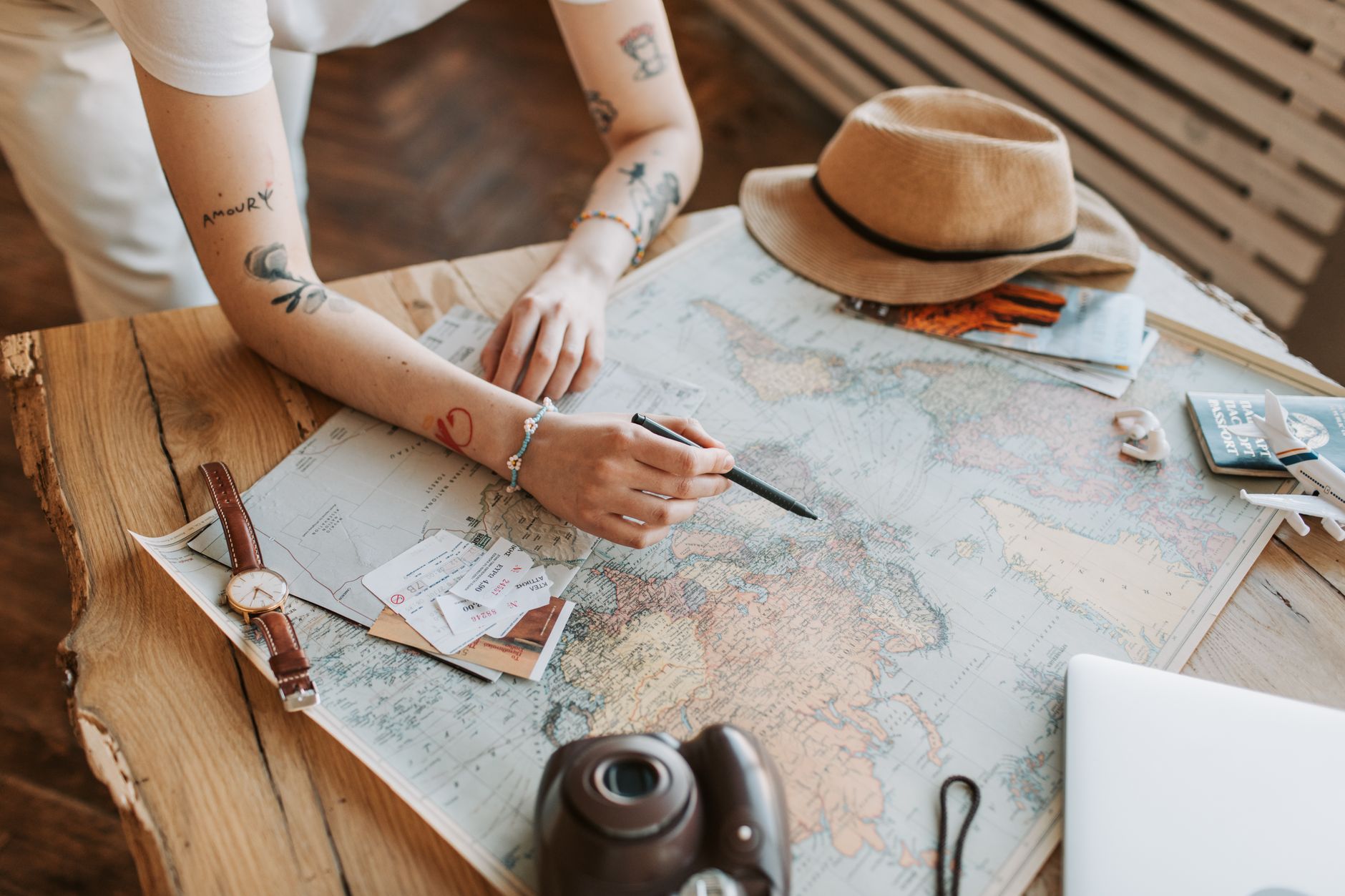 Traveler adding up nonrefundable flight and hotel costs on a laptop next to a passport