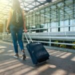 Woman with a suitcase at the airport heading out on a summer trip abroad