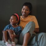 Adult daughter and her mother smiling together in a Mother's Day photo at home