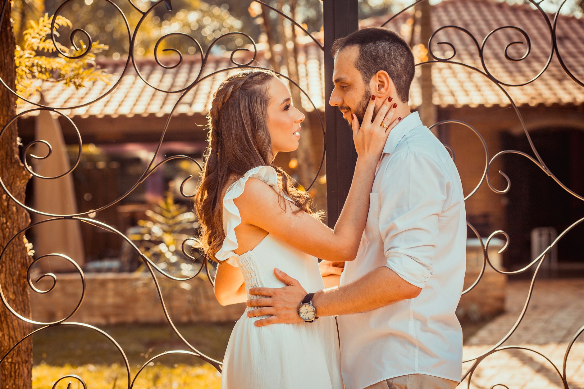 A couple sharing an intimate moment outdoors with a beautiful gate backdrop, captured in warm tones, illustrating IV. Non-Verbal Communication in Personal Relationships