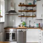 Contemporary small kitchen featuring stainless steel appliances and open shelving, illustrating Small Space Living: 20 Clever Organization Ideas for Apartments and Tiny Homes