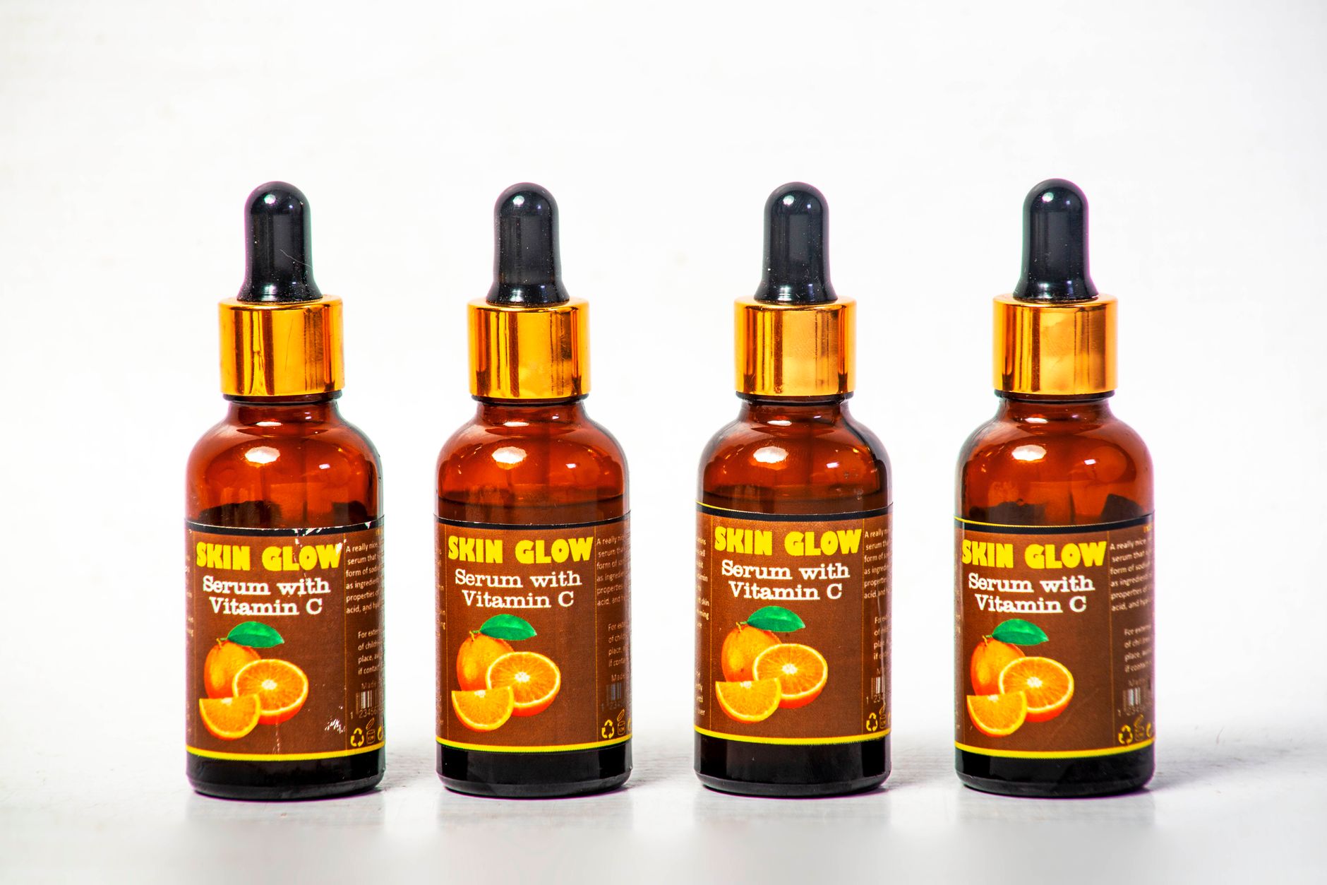 Four Vitamin C serum bottles arranged on a white background for skincare, illustrating Vitamin C: Your Brightening Powerhouse