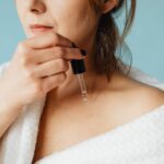 Close-up of a woman in a bathrobe applying serum for skincare routine, illustrating The Anti-Aging Skincare Guide: Ingredients That Actually Reduce Wrinkles and Fine Lines