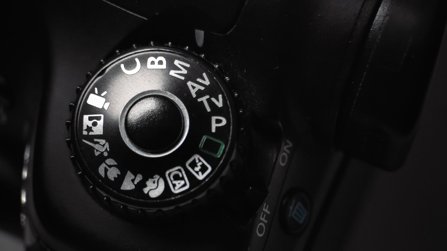 Detailed close-up of a DSLR camera mode dial showing various settings, illustrating Camera Settings for Different Scenarios