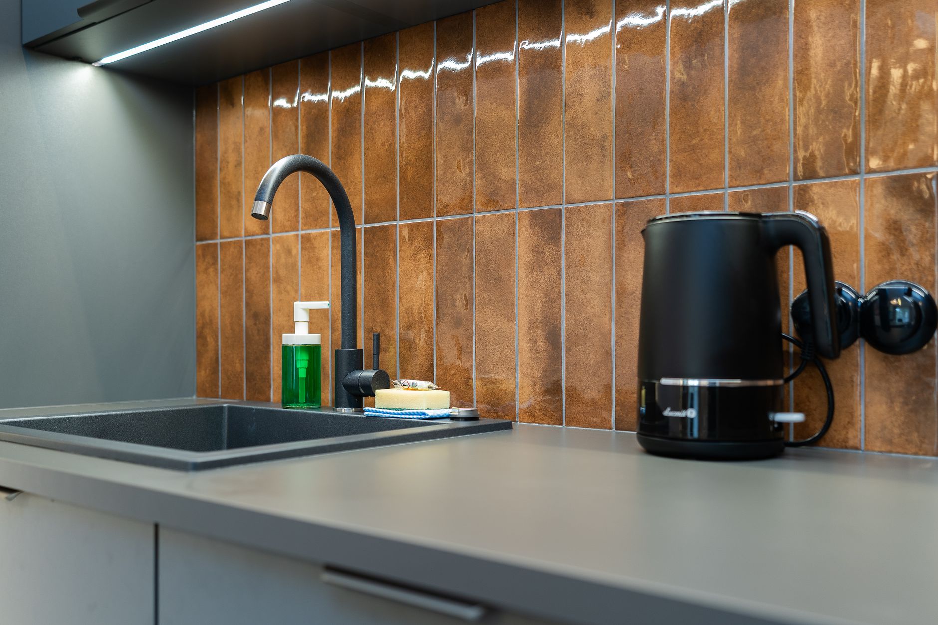 Contemporary kitchen counter setup with a sink, soap dispenser, and electric kettle, illustrating Kitchen: The Deep Cleaning Command Center